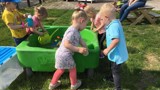 Kinderen spelen in de tuin met een bak water.