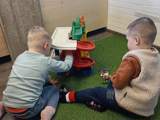Kinderen spelen binnen met speelgoed.
