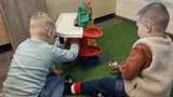Kinderen spelen binnen met speelgoed.