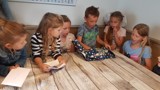 Kinderen openen een cadeau aan tafel.