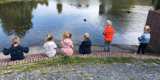 Kinderen zitten aan de kant van een meer.